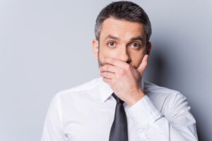 Man hiding his mouth due to oral health problems