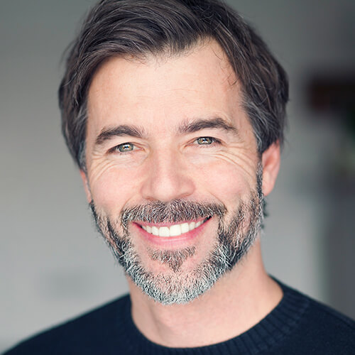 A middle age man with a beard smiling